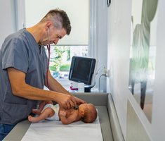 Lekarz badający noworodka.