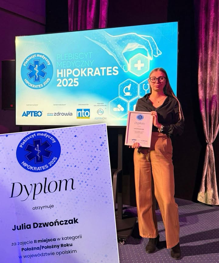 Młoda kobieta z dyplomem na tle sceny.