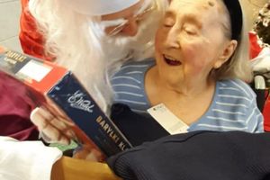 Dzieciak przyjmuje prezent od Świętego Mikołaja.