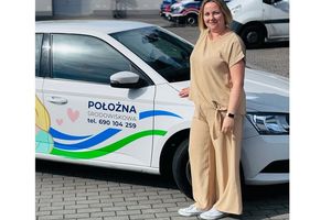 Położna obok samochodu służbowego.