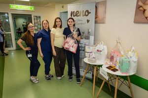 Cztery osoby przy stoisku z produktami dla dzieci.