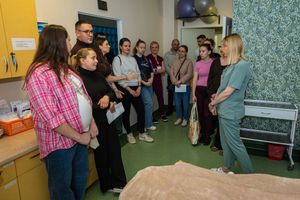 Grupa ludzi w sali szkoleniowej.