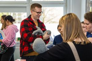 Mężczyzna z maskotką w grupie.