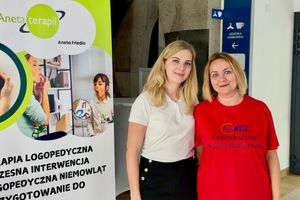 Kobiety przy plakacie logopedycznym.